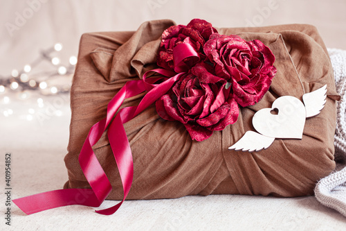 Valentine's Day gift decorated with roses and ribbons close up.