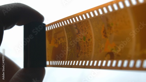 Watching Retro Pictures on Negative Plastic Film Strip Roll