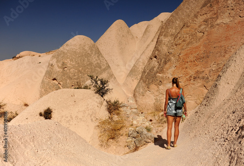 Back view of young woman walking in mountains