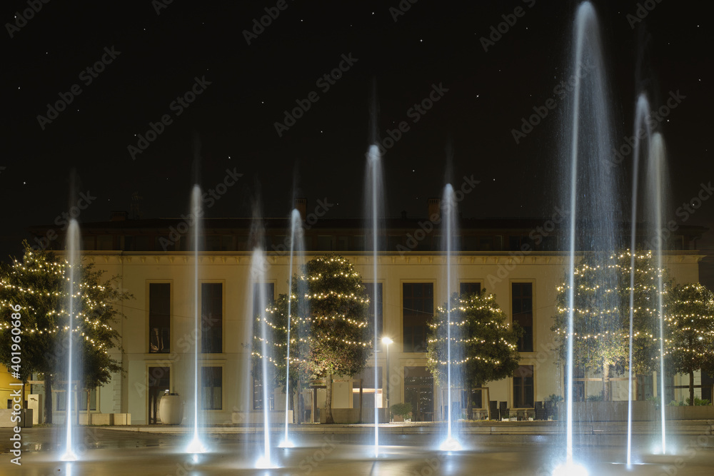 Christmas night, fountains at Ferdinando di Savoia square, starry sky, Peschiera del garda, Italy.