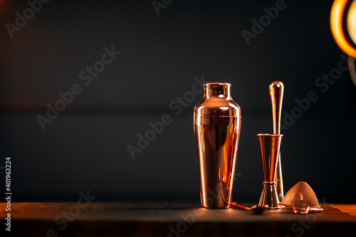 Side view on copper bar tools set with shaker on the wooden table photo