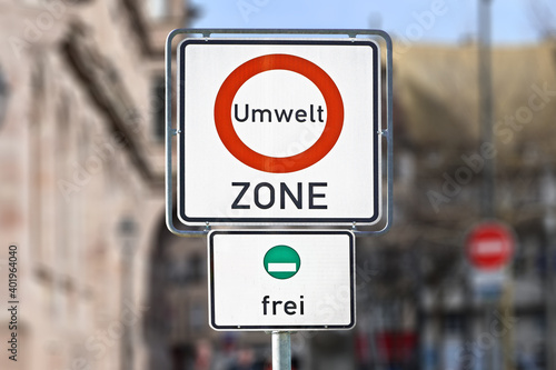 Road traffic sign marking a low emission zone in city centers in Germany translating as "Environmental Zone" and sign showing cars with green environmental badge a free to enter