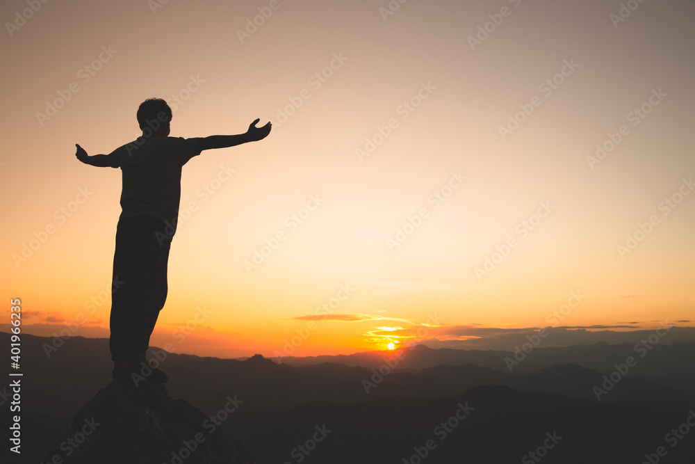 Man rise hand up on top of mountain and sunset,  Freedom and travel adventure concept. Religious beliefs, Copy space.