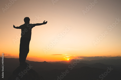 Man rise hand up on top of mountain and sunset,  Freedom and travel adventure concept. Religious beliefs, Copy space. © Tinnakorn