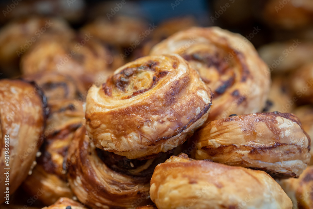 Fototapeta premium Small Danish pastries with raisins, chocolate chips, and vanilla cream, sold in a sweets store