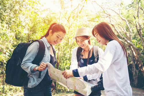 Group women traveler with backpack adventure holding map to find directions and walking relax in the jungle forest outdoor for destination leisure education nature on vacation