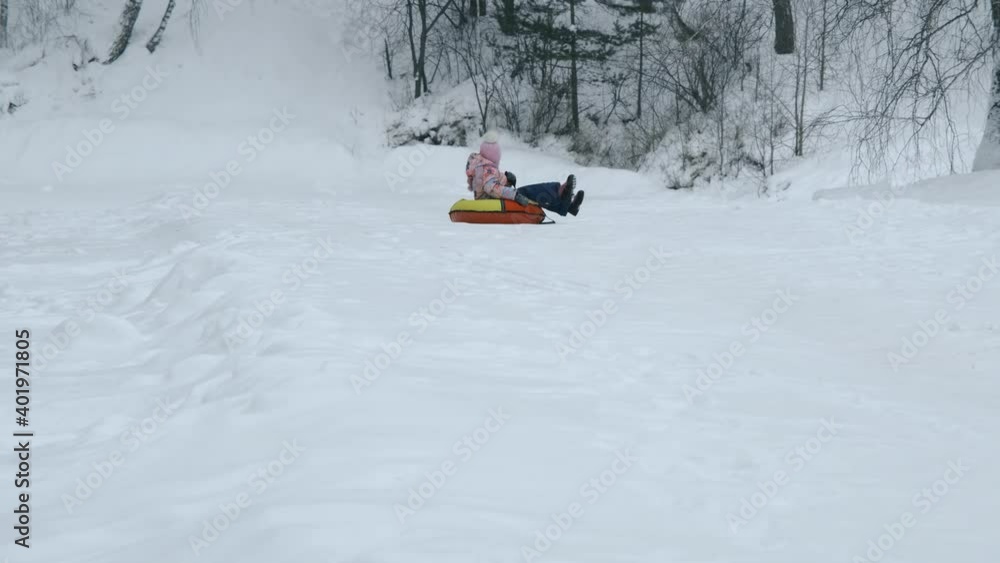 Cute 6-year old Little Girl Riding on the Tubing from a Hill. Winter Sport Activities, Leisure and People Concept Cute 6-year old Little Girl Riding on the Tubing from a Hill. Winter Sport Activities, Leisure and People Concept
