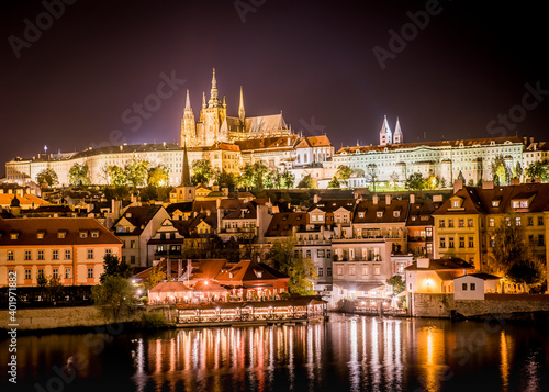 View of the city of Prague with St. Vitus Cathedral on the hill and the Vltava river at night
