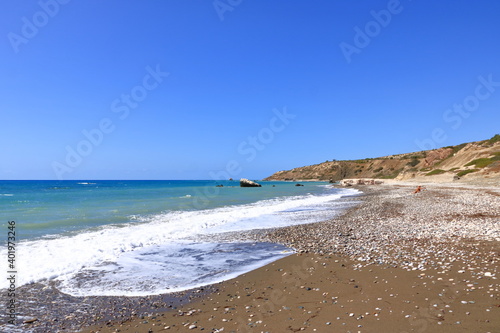 Aphrodite Beach with Stone Rocks in Aphrodite bay of Mediterranean sea water, blue sky in sunny day background, Petra tu Romiou, Cyprus