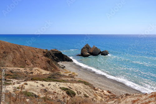 Fototapeta Naklejka Na Ścianę i Meble -  Aphrodite Beach with Stone Rocks in Aphrodite bay of Mediterranean sea water, blue sky in sunny day background, Petra tu Romiou, Cyprus