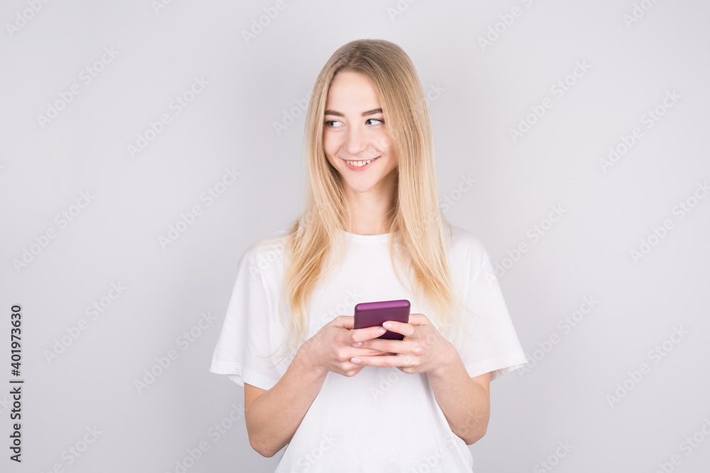 Photo of cheerful cute beautiful young woman chatting by mobile phone isolated over white wall. Looking aside to copyspace. Photo of cheerful cute beautiful young woman chatting by mobile phone isolated over white wall. Looking aside to copyspace.
