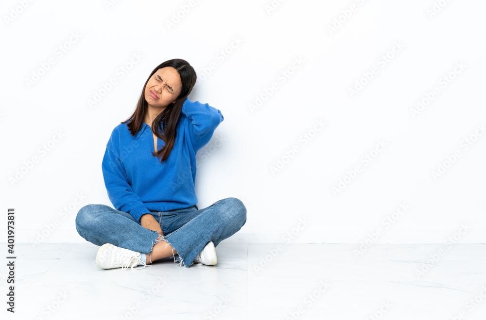 Young mixed race woman sitting on the floor isolated on white background with neckache Young mixed race woman sitting on the floor isolated on white background with neckache