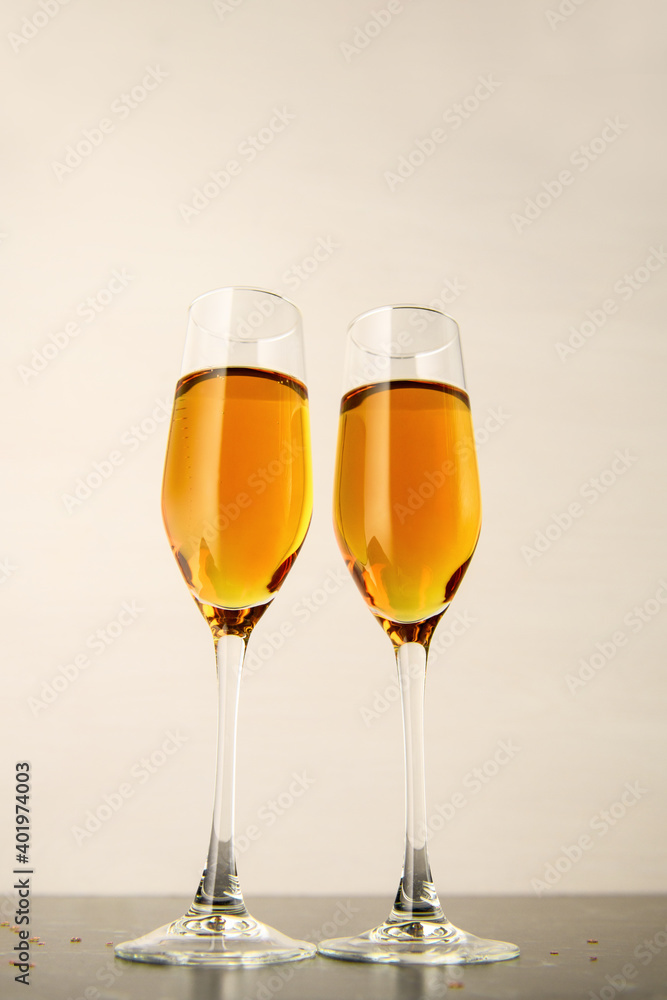 Two glasses of champagne on a gray background. Alcoholic drink: champagne, beer, white wine. New year and Christmas background. Valentine's Day. Vertical photo Two glasses of champagne on a gray background. Alcoholic drink: champagne, beer, white wine. New year and Christmas background. Valentine's Day. Vertical photo