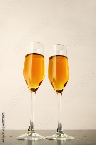 Two glasses of champagne on a gray background. Alcoholic drink: champagne, beer, white wine. New year and Christmas background. Valentine's Day. Vertical photo