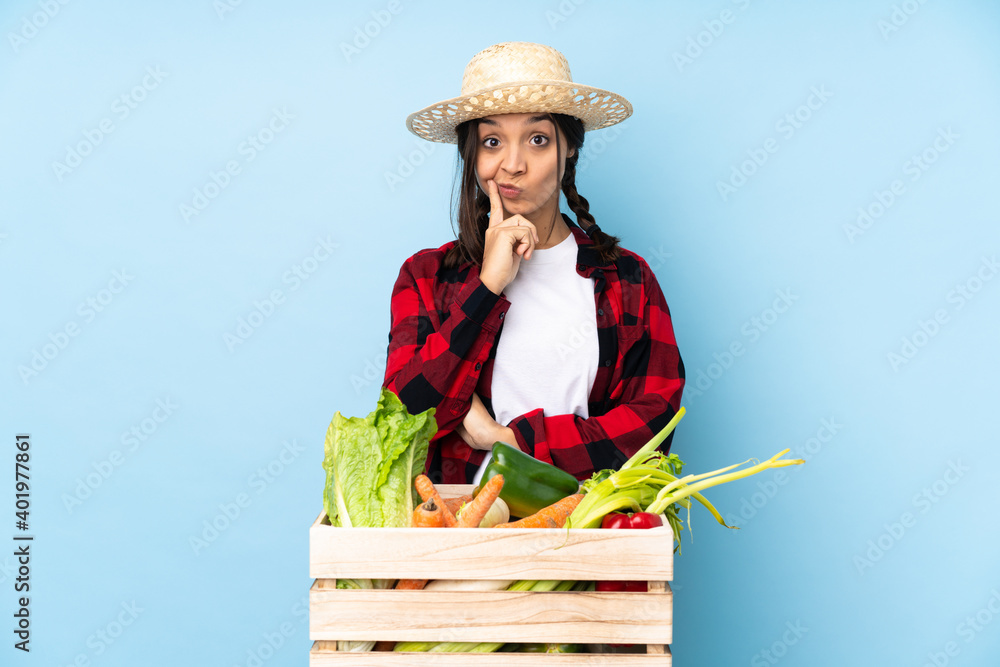 Young farmer Woman holding fresh vegetables in a wooden basket and looking front