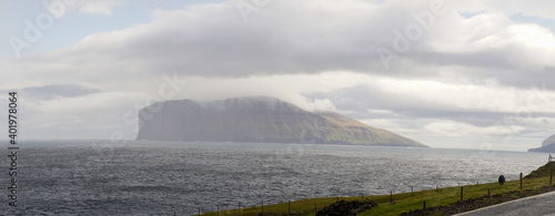 Green mountain landscapes with steep cliffs into the ocean near Gjogv village on the Faroe Islands in Denmark. photo