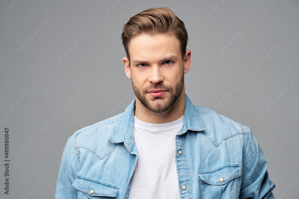 Portrait of young handsome caucasian man in jeans shirt over light background Portrait of young handsome caucasian man in jeans shirt over light background