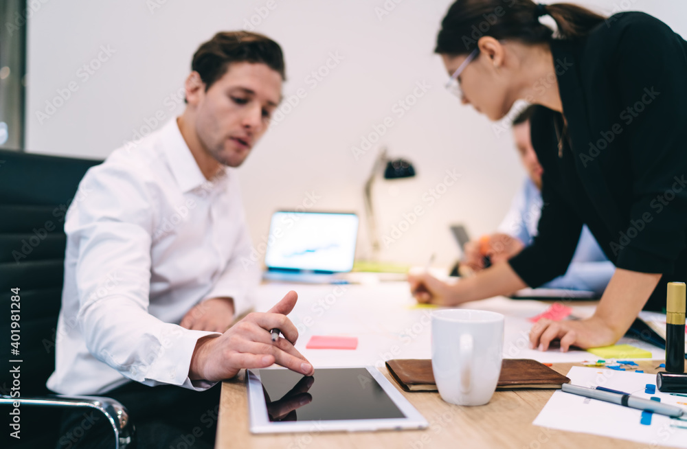 Focused businessman using tablet during work in office with colleagues Focused businessman using tablet during work in office with colleagues
