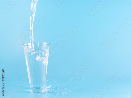 Glass with water aqua on blue background © Liza