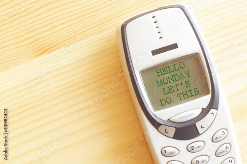 Hello Monday, let's do this. motivational quote about Monday and week start, on old phone