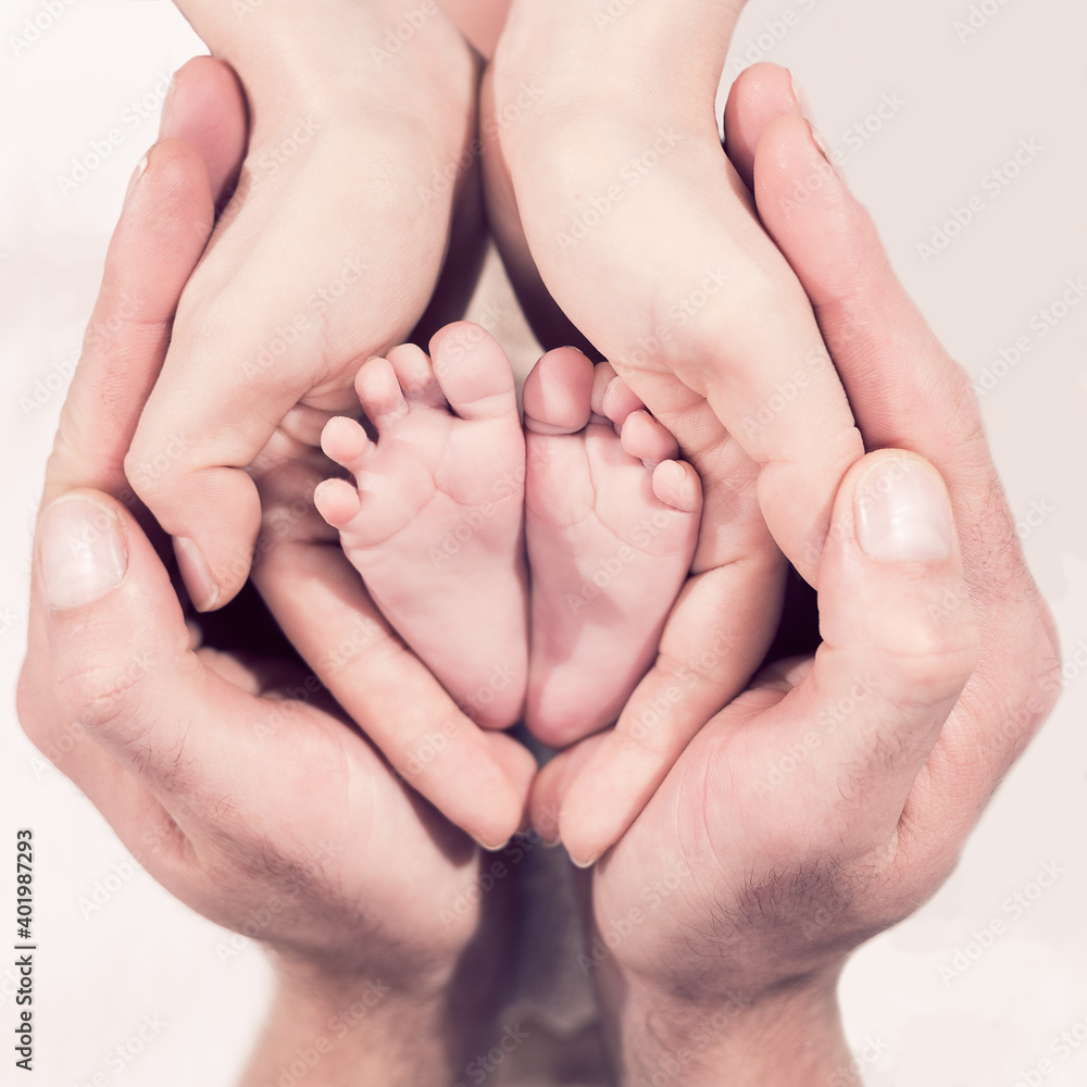 Babyfüße umrahmt von den Händen der Eltern