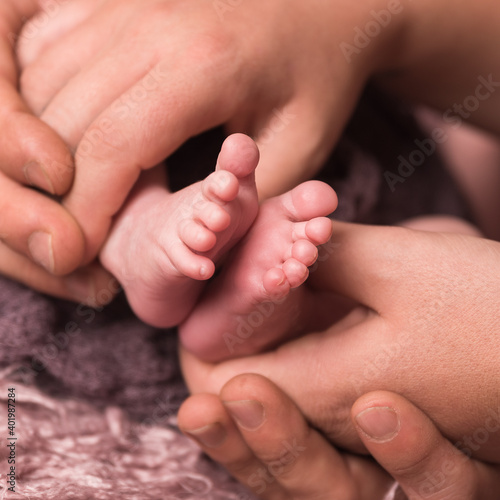 Babyfüße werden von den Händen der Eltern gehalten
