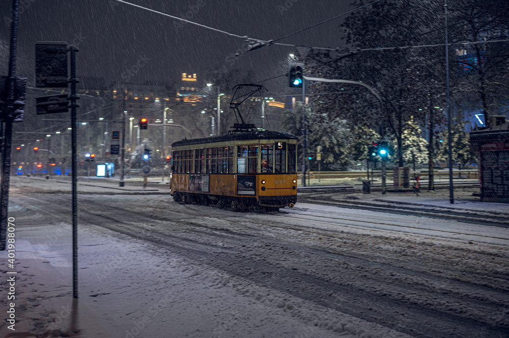 Obraz premium The old tram under the snow in Milan by night
