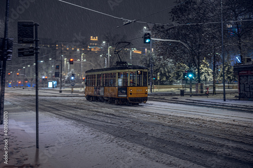 The old tram under the snow in Milan by night