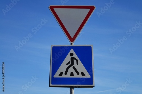 Road sign Pedestrian Crossing against the background of a blue sky