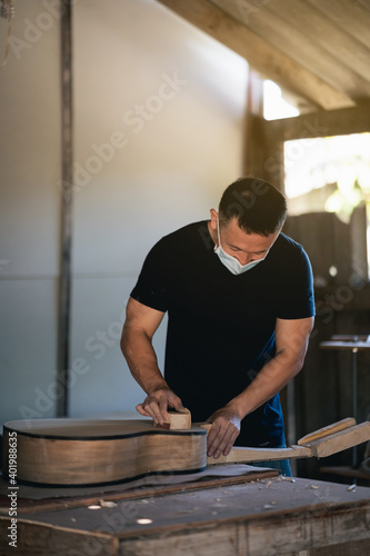 craft man making guitar on wood table, capenter working concept photo