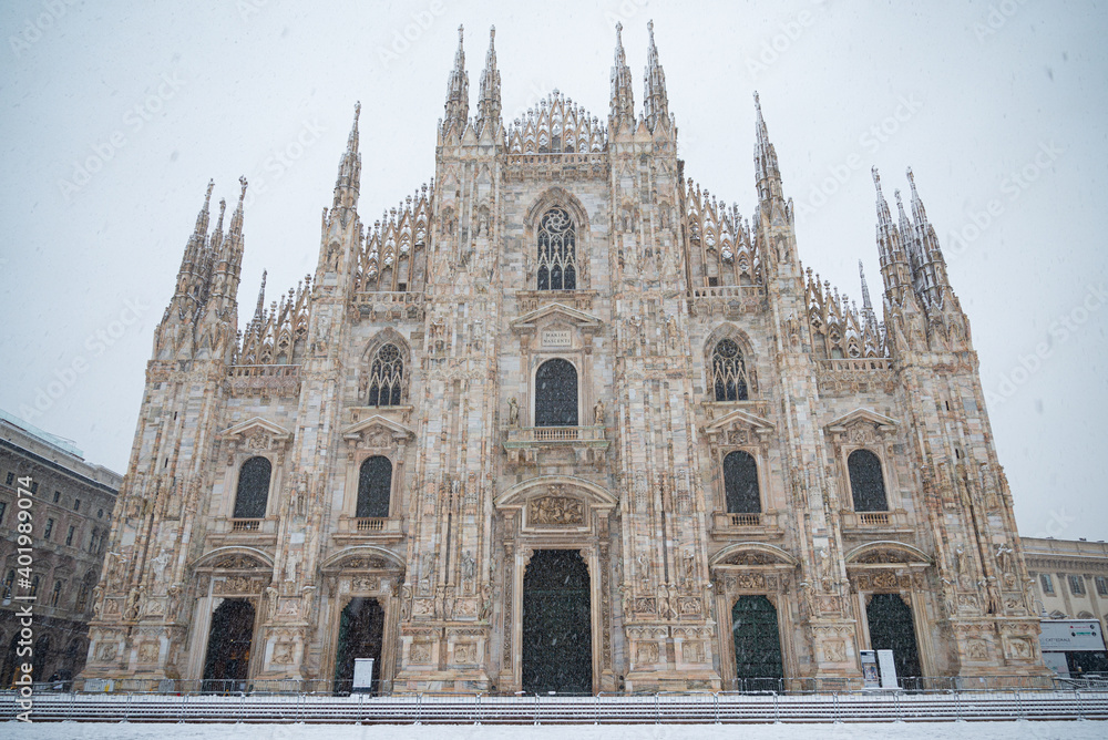 The facade of Milan cathedral (called Duomo) during a heavy snowfall