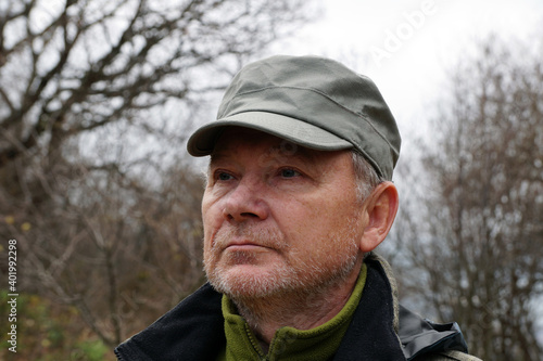 portrait of an older man in a cap on the background of nature