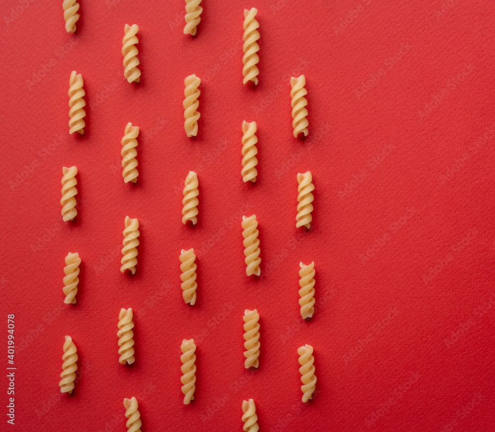 layout made of pasta - flat lay on red background layout made of pasta - flat lay on red background