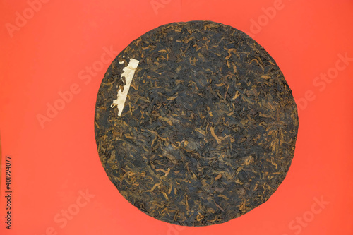 China Yunnan Puer tea cake. Red background. Minimalism. Copy space. Mockup.