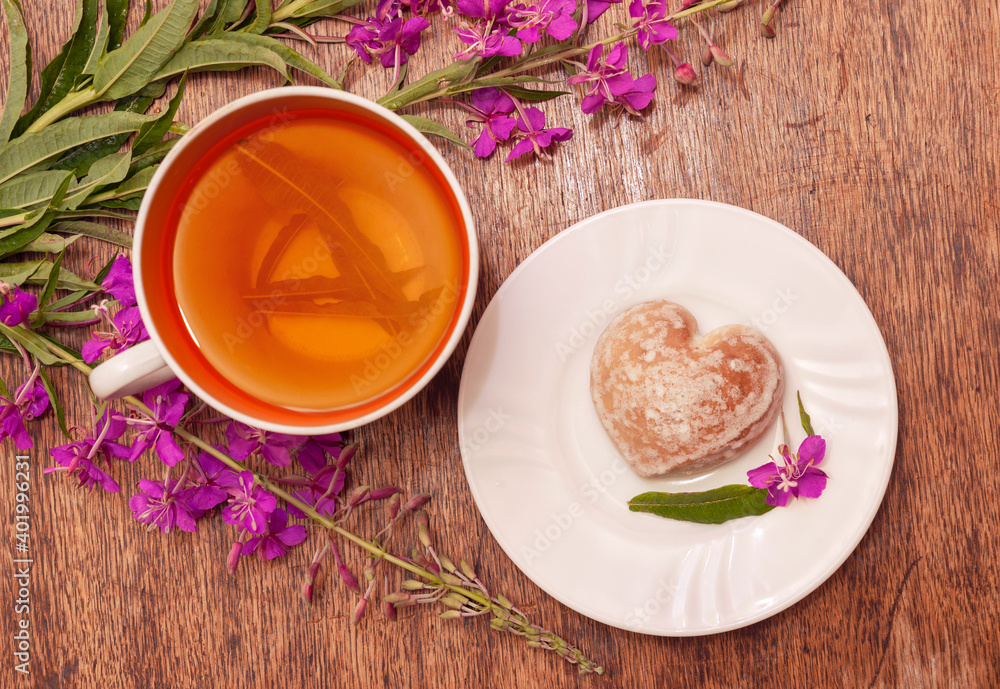 Still life photo with herbal tea from fireweed leaves and gingerbread on a wooden background Still life photo with herbal tea from fireweed leaves and gingerbread on a wooden background