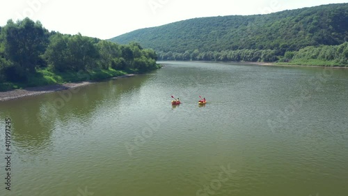 Flight through majestic river Dnestr with two packrafters on yellow and red rubber boats. Dniester canyon, Ukraine, Europe. Aerial UHD 4k drone video photo