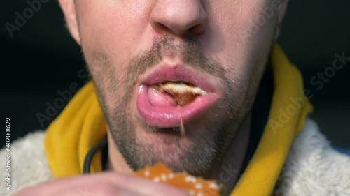 portrait of angry man eating hamburger at fast food cafe.