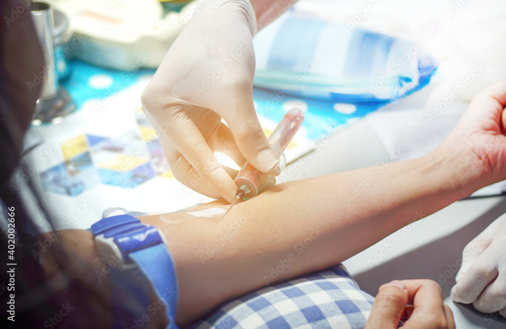 Close-up of a nurse, doctor or medical technician wearing rubber gloves, taking a blood sample from a patient in the hospital. Close-up of a nurse, doctor or medical technician wearing rubber gloves, taking a blood sample from a patient in the hospital.