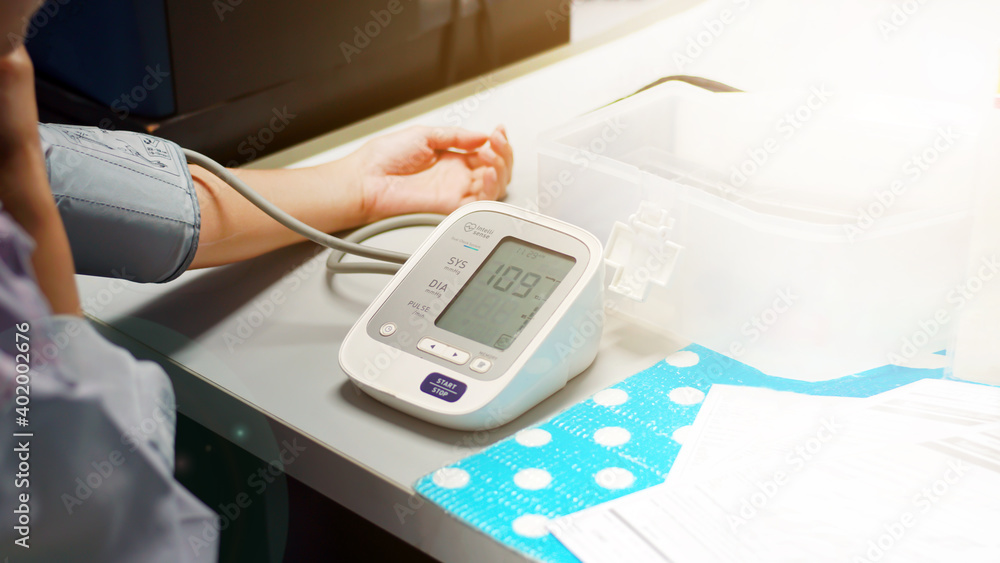 Check women's health,and heart rate with digital pressure gauge standard blood pressure test results .Health and Medical concept. Check women's health,and heart rate with digital pressure gauge standard blood pressure test results .Health and Medical concept.