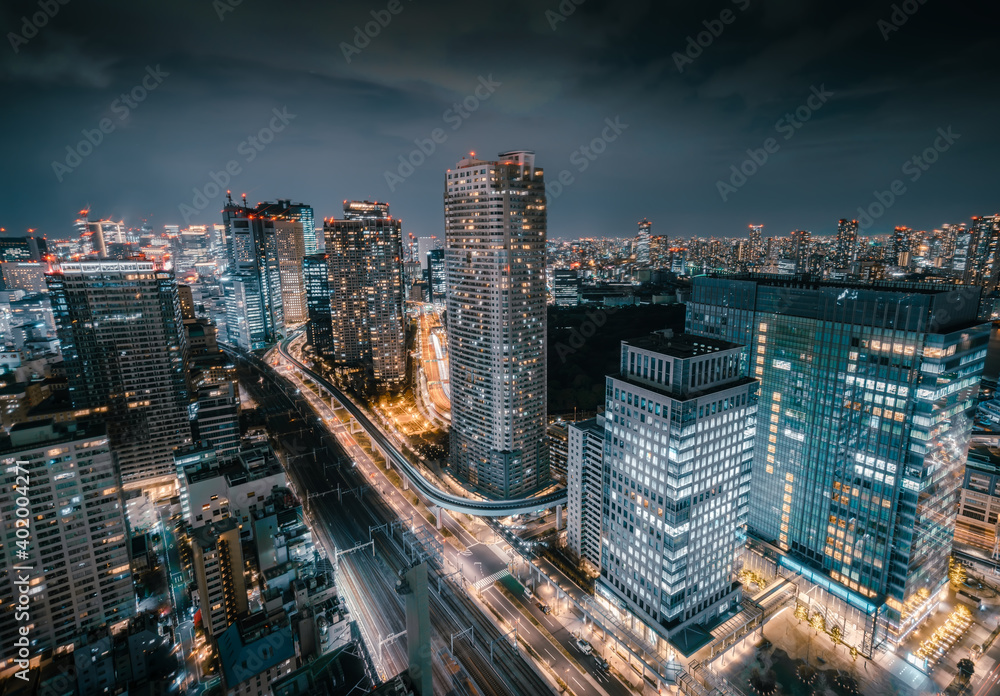 Fototapeta premium Aerial View of Skyscraper Rooftops and Futuristic Skyline at Night with Bright Lights in Tokyo, Japan
