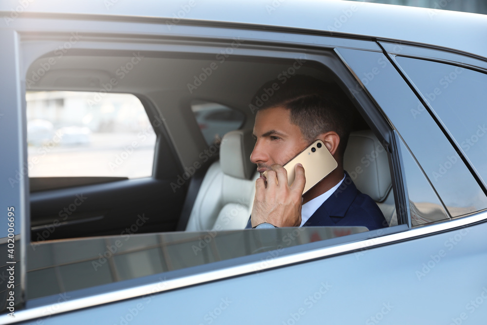 Handsome man talking on phone in modern car Handsome man talking on phone in modern car