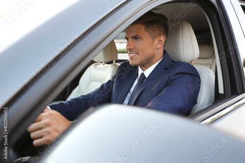 Handsome man driving his modern car, view from outside © New Africa