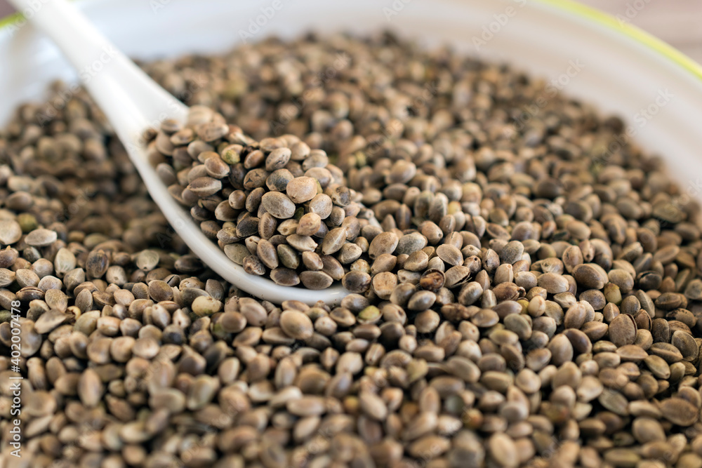 Close up of cannabis seeds in ceramic dish with ceramic spoon. Close up of cannabis seeds in ceramic dish with ceramic spoon.