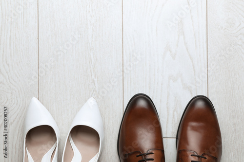 Wedding shoes on white wooden floor, flat lay. Space for text