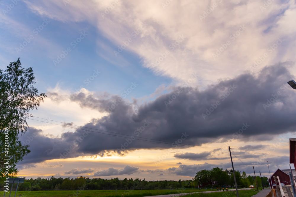 A beautiful landscape of a weather front drifting across Cheltenham at sunset, blue sky with massive clouds A beautiful landscape of a weather front drifting across Cheltenham at sunset, blue sky with massive clouds