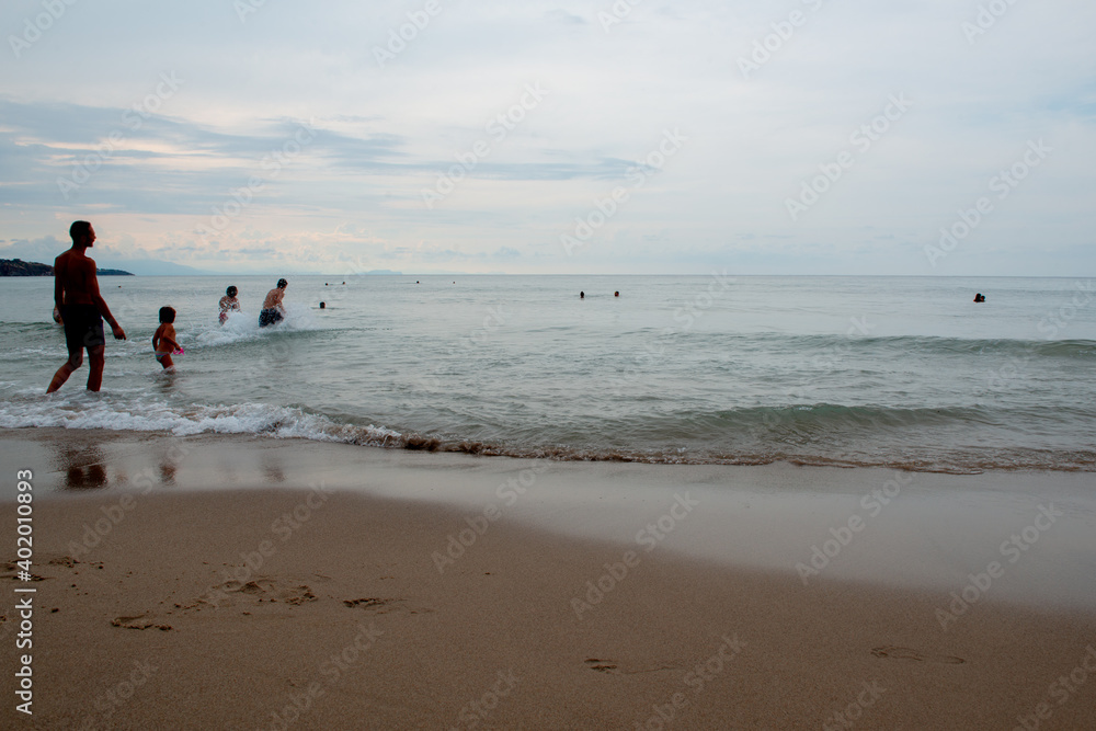 People swimming in calm Mediterranean sea in Sicily (Italy) at sunset People swimming in calm Mediterranean sea in Sicily (Italy) at sunset