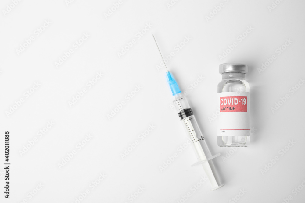 Vial with coronavirus vaccine and syringe on white background, flat lay. Space for text Vial with coronavirus vaccine and syringe on white background, flat lay. Space for text