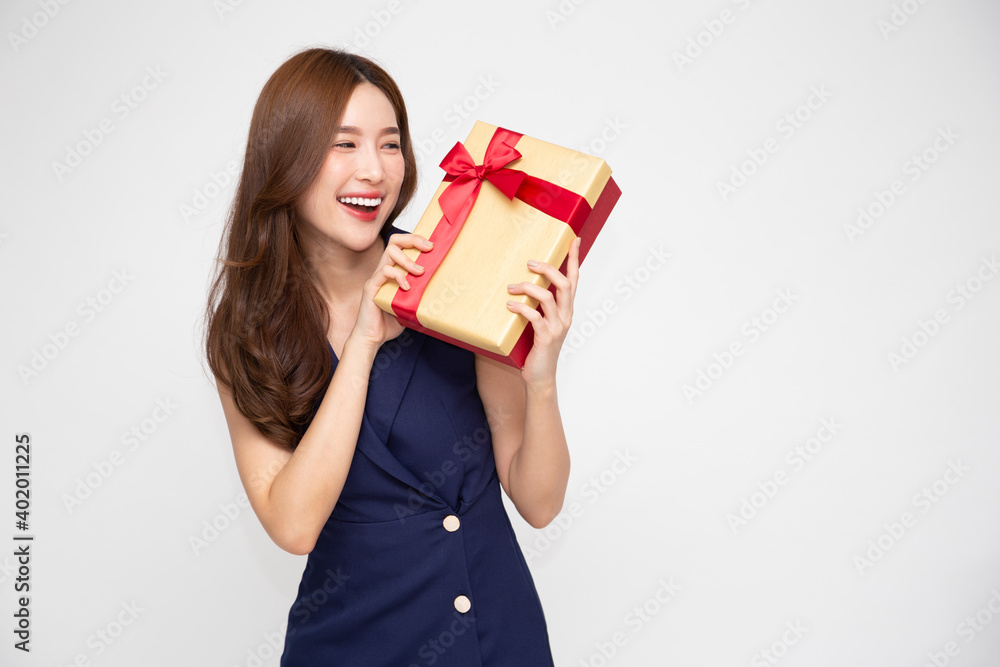 Happy beautiful Asian woman smile with gold gift box isolated on white background. Teenage girls in love, Receiving gifts from lovers. New Year, Christmas and Valentines Day concept Happy beautiful Asian woman smile with gold gift box isolated on white background. Teenage girls in love, Receiving gifts from lovers. New Year, Christmas and Valentines Day concept