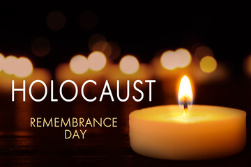 International Holocaust Remembrance Day. Burning candle on black table, closeup