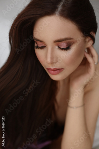 Beautiful portrait of European young model woman with perfect evening makeup and beautiful long healthy hair